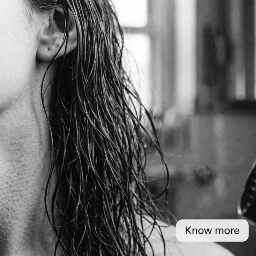 Close-up of a person with wet hair in a blurred indoor setting